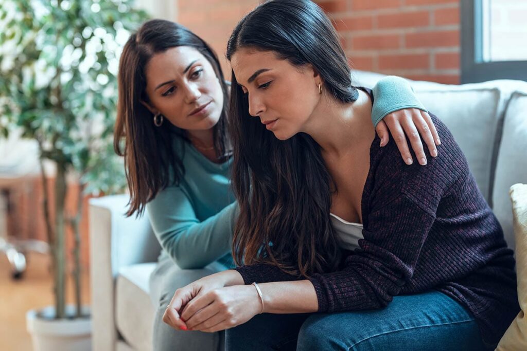 a person comforts another after learning how to get someone into addiction treatment