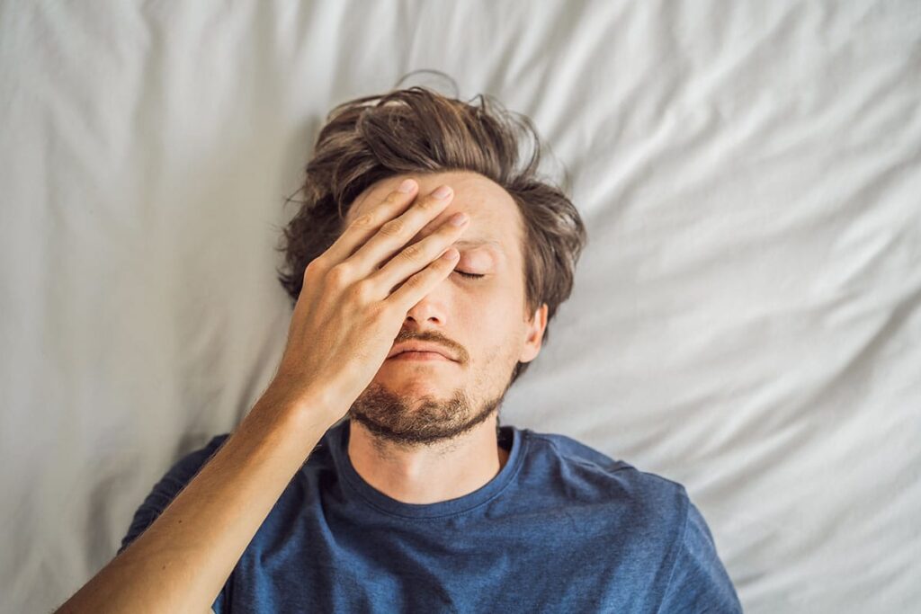 Man in bed dealing with the signs of heroin use