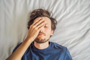 Man in bed dealing with the signs of heroin use