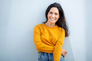 woman in yellow sweater considers reasons to drink less alcohol