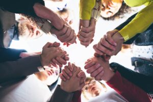 group clasping hands in inpatient drug rehab