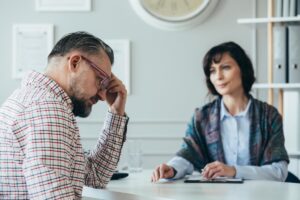 man in glasses talks to wife in sweater about coping with anger