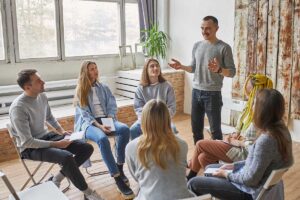 man speaking to group about what is the dharma recovery program