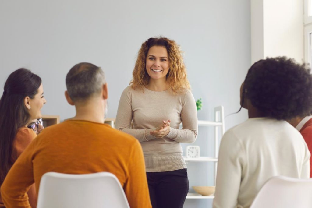 woman with curly hair talking with group in opioid rehab in mississippi