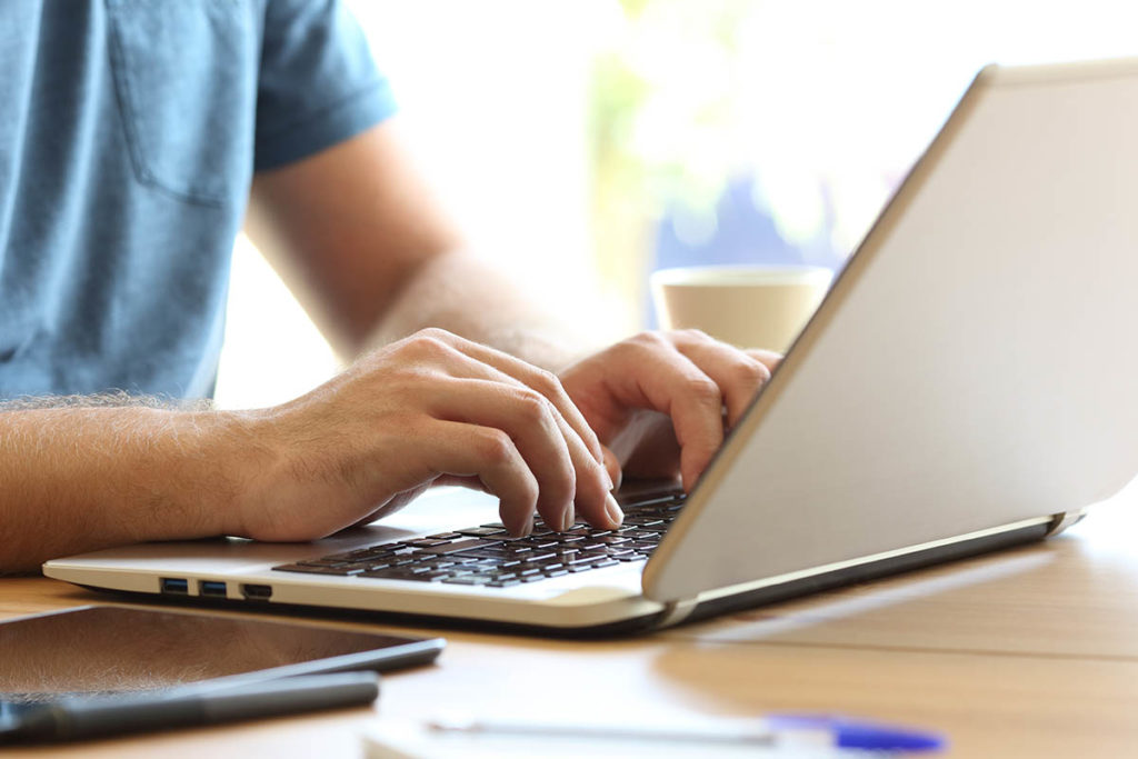 man types on laptop looking for drug detox in mississippi