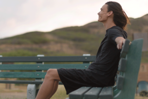 person sits on a bench outside and thinks about the benefits of vivitrol for alcohol addiction