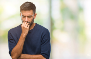worried man bites his nails and wonders about signs of an anxiety attack
