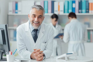 a doctor with his hand folded and leaning over desk explains franciscan missionaries of our lady health insurance coverage for drug and alcohol rehab