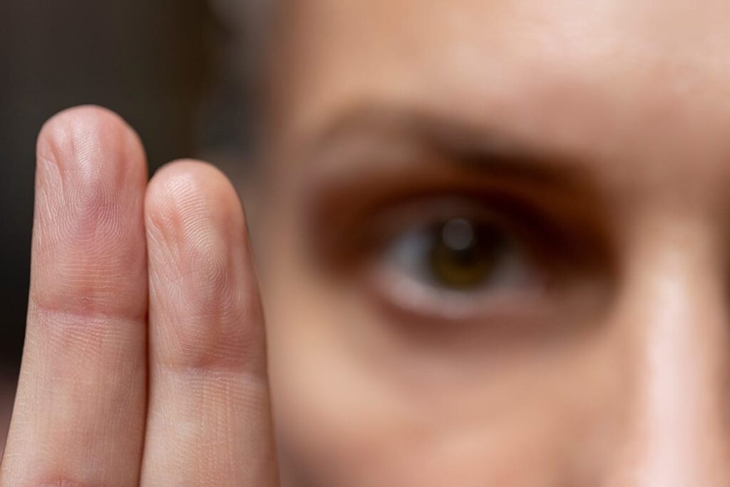 a photo of a persons eye and two fingers being held up while learning more about what is emdr therapy