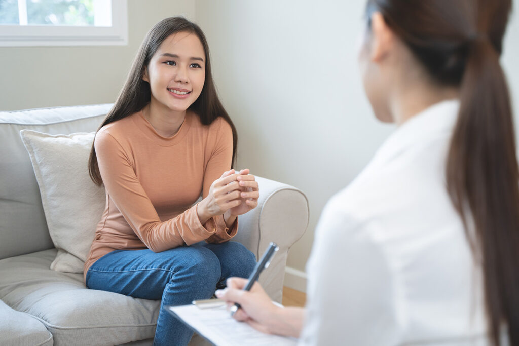 a smiling woman sits on a couch and asks her therapist what is emdr therapy