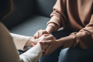 a medical professional holds a patients hands while discussing how an drug and alcohol detox can help them achieve a substance-free life