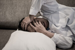 man lays in bed with hand over his face struggling with meth withdrawal symptoms