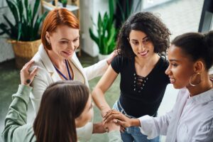 women stand in a circle while at a women's inpatient rehab and participate in group therapy