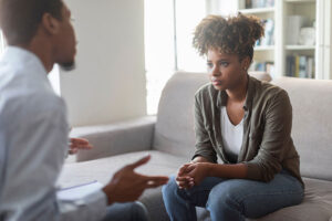 a woman sits on a couch and listens carefully to her therapist in her fentanyl addiction treatment