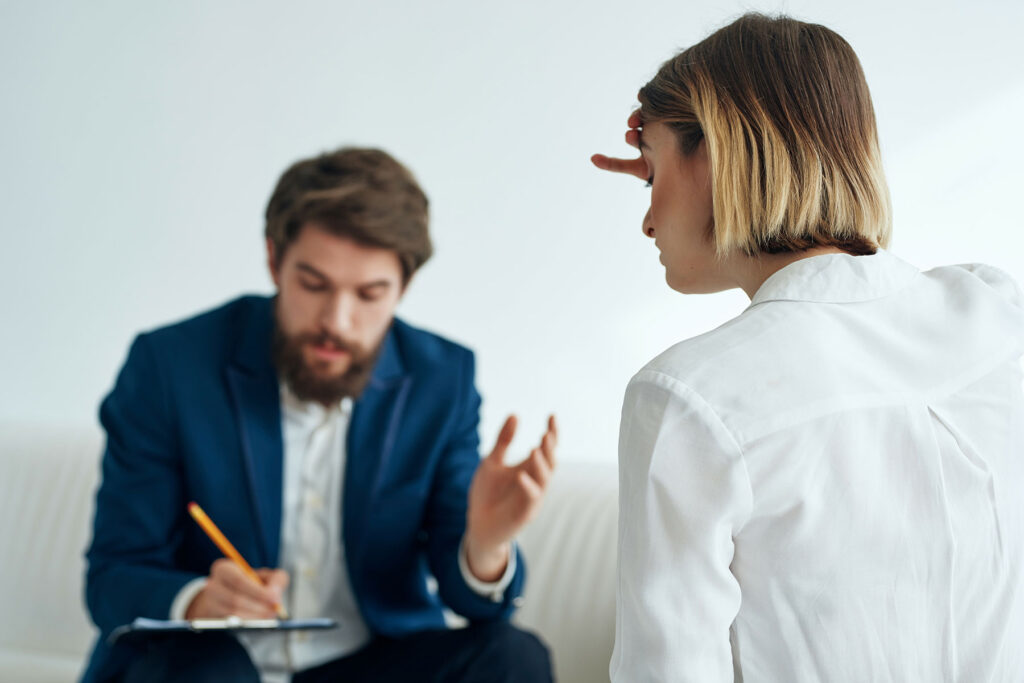 a man sits and takes note as a woman talks to him about the benefits of inpatient cocaine addiction treatment