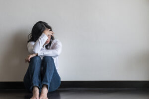a person holds their head with their hand after recognizing self-destructive behaviors in recovery