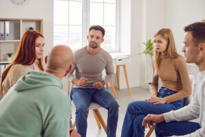 people in group therapy supporting one another as part of a sober living program