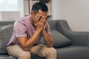 a person holds their face in their hands after recognizing signs of IV drug use