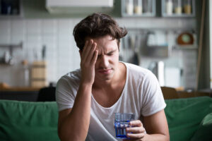 a young man feels ill after waking up from an alcohol blackout