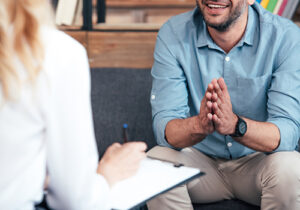 a man sits and talks to his therapist in his trauma therapy program