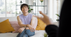 a person sits on a couch while listening to their therapist talks to them during their stay at an lgbtq rehab