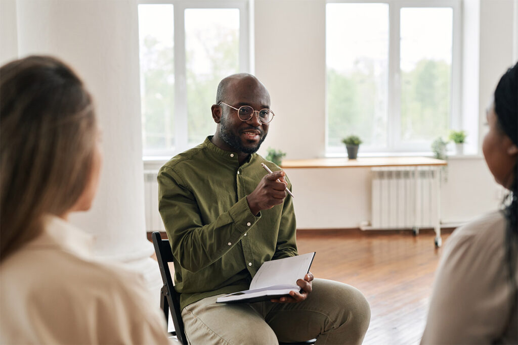 a therapist leads an experiential therapy group session