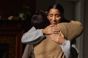 a woman hugs a loved one who has helped her cope in addiction recovery