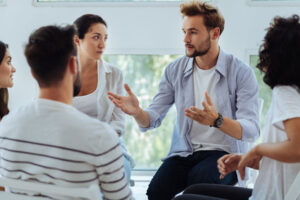 a man talks to a group of people about how helpful a drug detox center was for his recovery