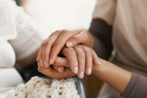 A person holds the hand of another person while discussing intervention services