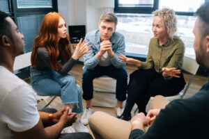 a group of people sit and listen and talk during their narcotics anonymous meetings