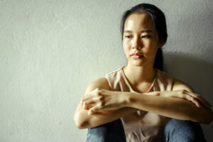 woman leans on a wall thinking about cross addiction