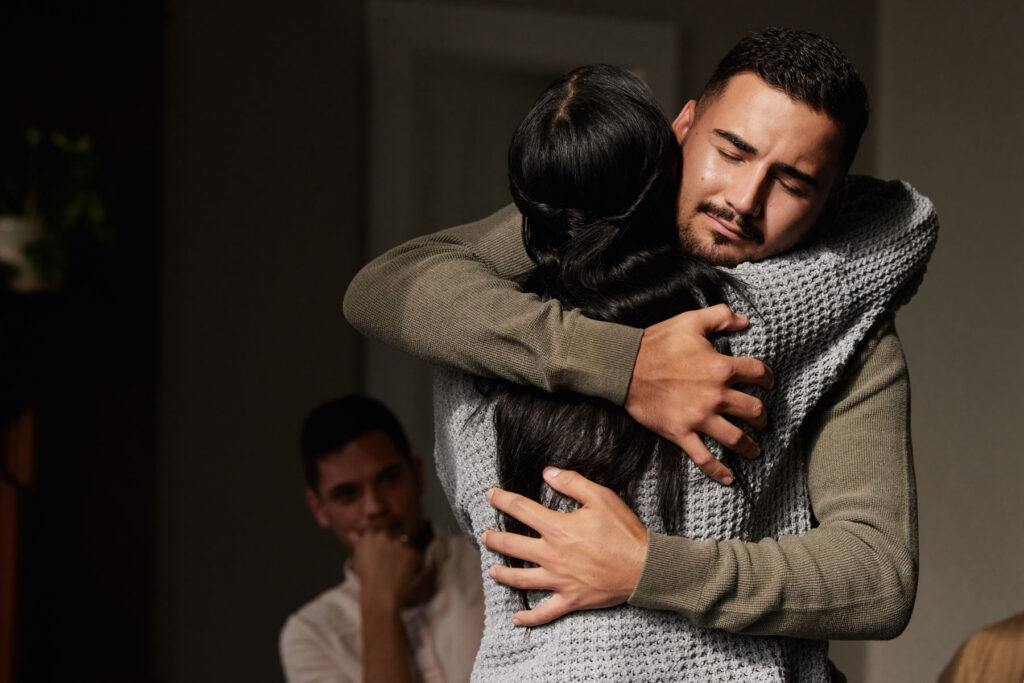 two people hug while one person asks themselves what is trauma bonding