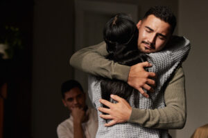 two people hug while one person asks themselves what is trauma bonding