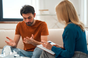 concerned man talking to his therapist asking her if co-occurring disorders treatment is right for him