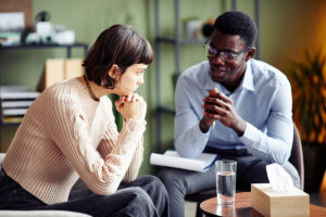 two people sit near each other and are talking about the benefits of treatment at prescription drug rehab