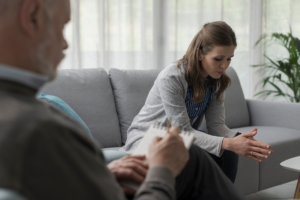 a woman sits on a couch and talks to her therapist about her fear in recovery