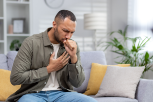 man sitting and coughing after asking the question what are inhalants