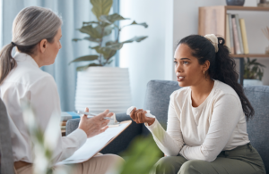 a woman sits on a couch and asks her therapist how long does rehab last