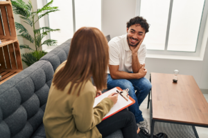 man sits on a couch with his therapist asking about rehab success rate